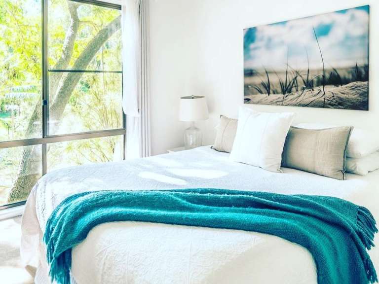 Ein Schlafzimmer mit einem Bett und einem Gemälde an der Decke