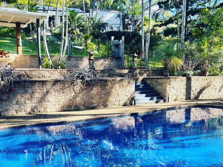 Ein großer blauer Pool mit einem Haus im Hintergrund