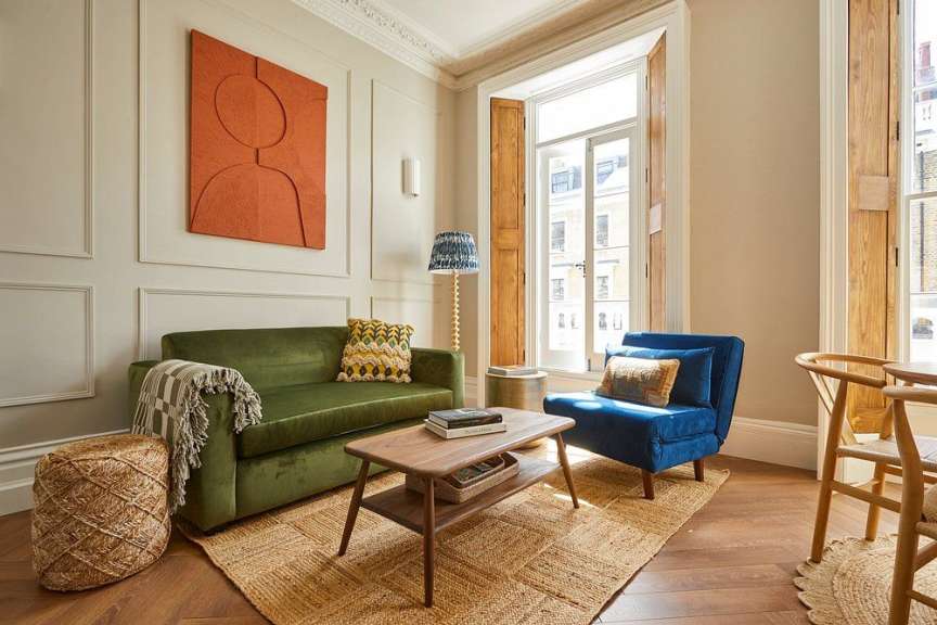 Ein Wohnzimmer mit einer grünen Couch und zwei blauen Stühlen