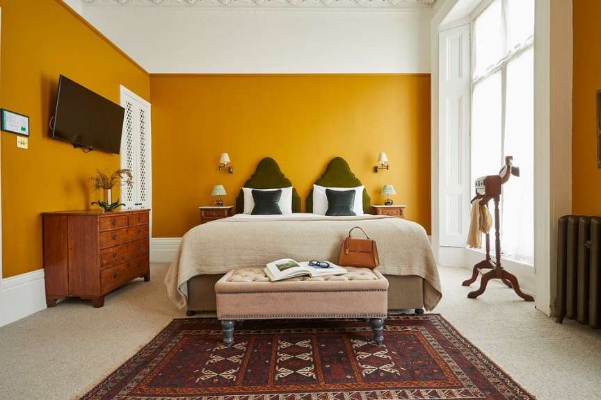 Ein Schlafzimmer mit gelben Wänden und einem Bett