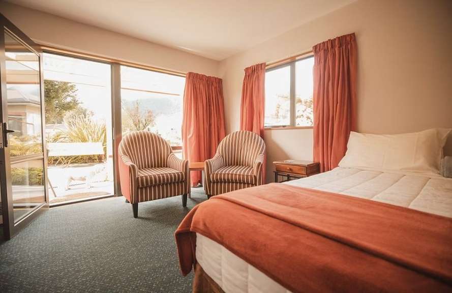 Ein Schlafzimmer mit einem Bett und zwei Stühlen