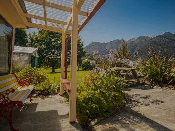 Eine rote und gelbe Bank sitzt auf einer Veranda mit Blick auf die Berge