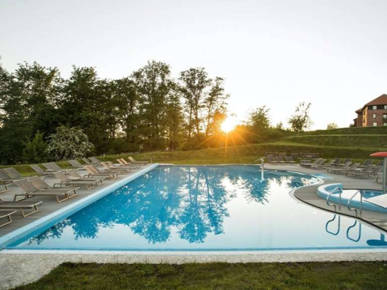 Ein großer Swimmingpool mit Liegestühlen umgeben