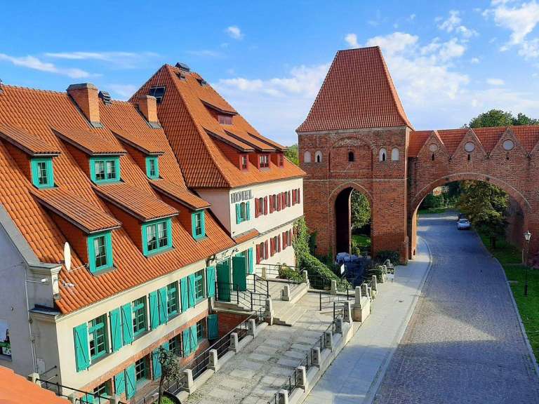 Eine Reihe von Gebäuden mit roten Dächern und grünen Fensterläden
