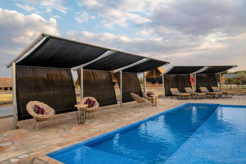 Ein Swimmingpool mit Liegestühlen und Sonnenschirmen umgeben