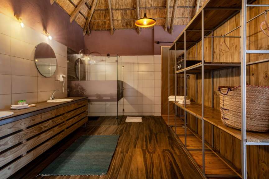 Ein Badezimmer mit Waschbecken und Regalen aus Holz