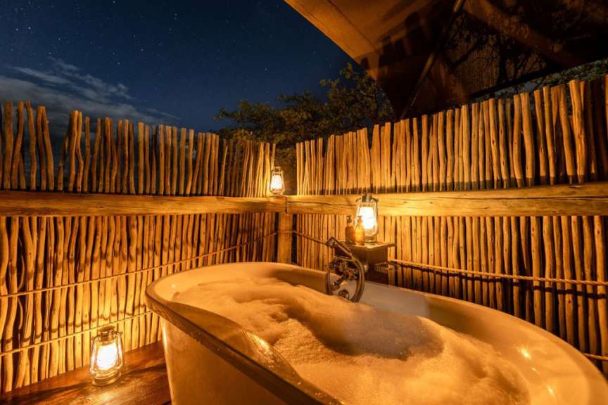 Eine Badewanne mit Schaum und Laternen davor