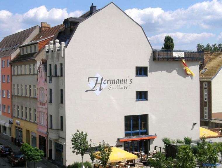 Ein weißes Gebäude mit dem Namen hermann 's stilhotel darauf