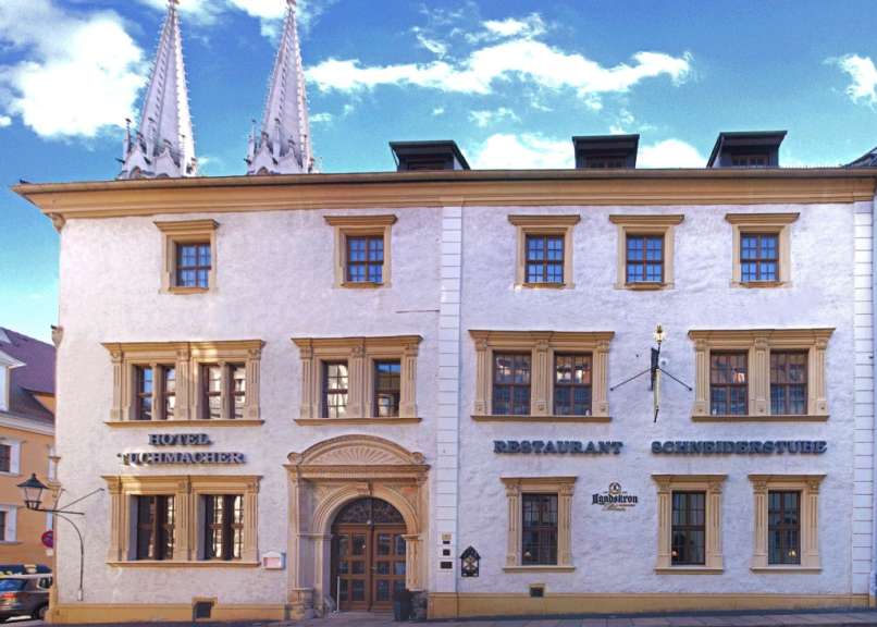 Ein weißes Gebäude mit der Aufschrift „ hotel tuchmacher “ darauf