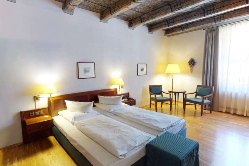 Ein Hotelzimmer mit zwei Betten und zwei Stühlen