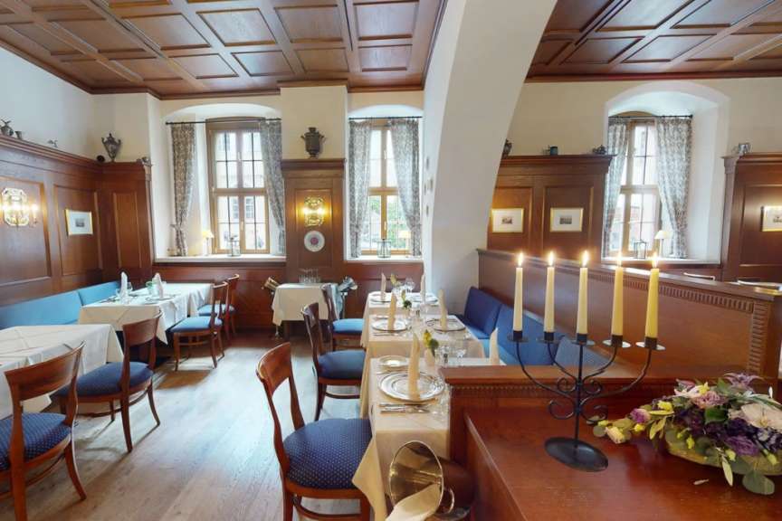 Ein Esszimmer mit vielen Tischen und Stühlen und Kerzen