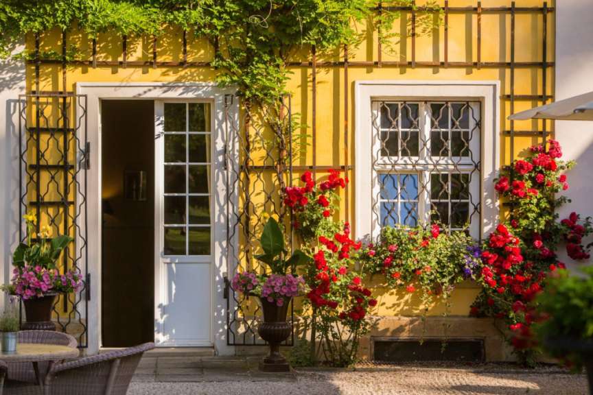 Ein gelbes Haus mit einer weißen Tür und zwei Fenstern