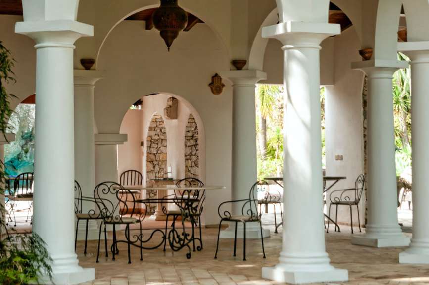 Eine weiße Veranda mit einem Tisch und Stühlen darauf