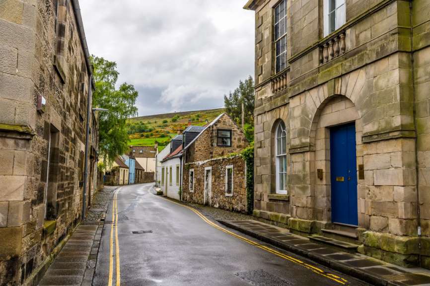Eine Straße mit einem blauen Haus an der Seite