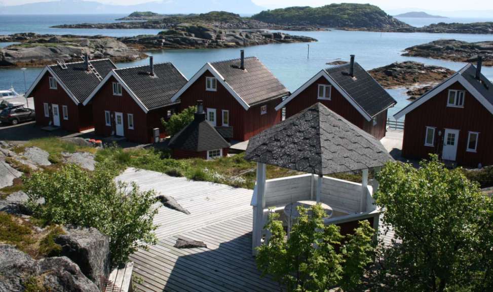Eine Gruppe von roten Häusern neben einem See