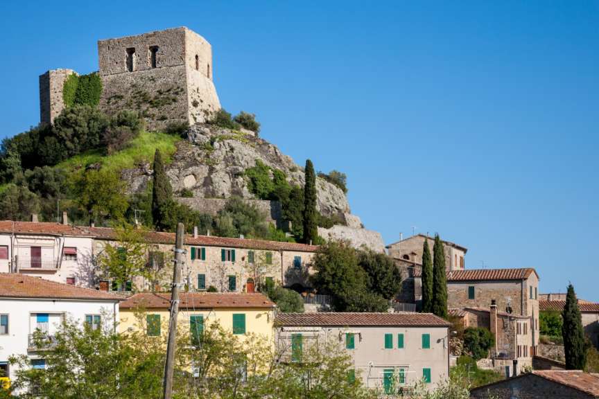 Ein kleines Dorf auf einem Hügel mit einem Turm darauf