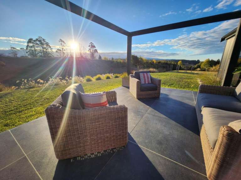 Ein Wohnzimmer mit Stühlen und einer Couch unter einer Pergola