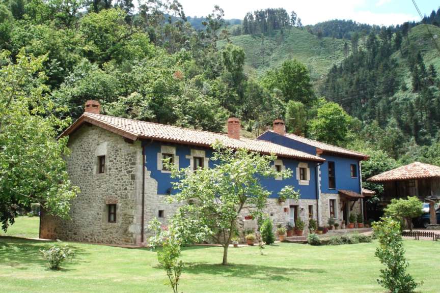 Ein großes blaues Steinhaus mit einem roten Dach