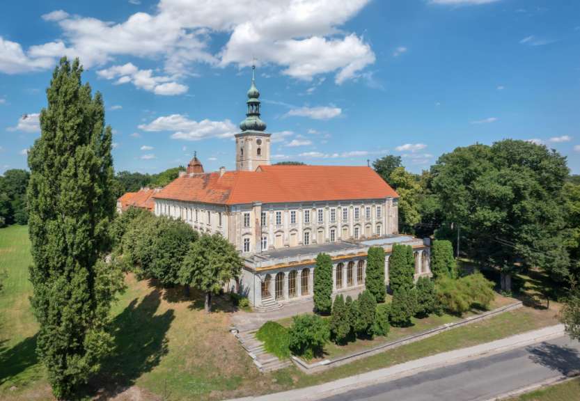 Ein großes Gebäude mit einem roten Dach und einem Turm darauf