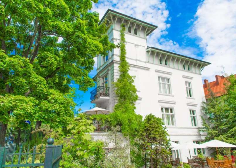 Ein großes weißes Gebäude mit vielen Bäumen davor