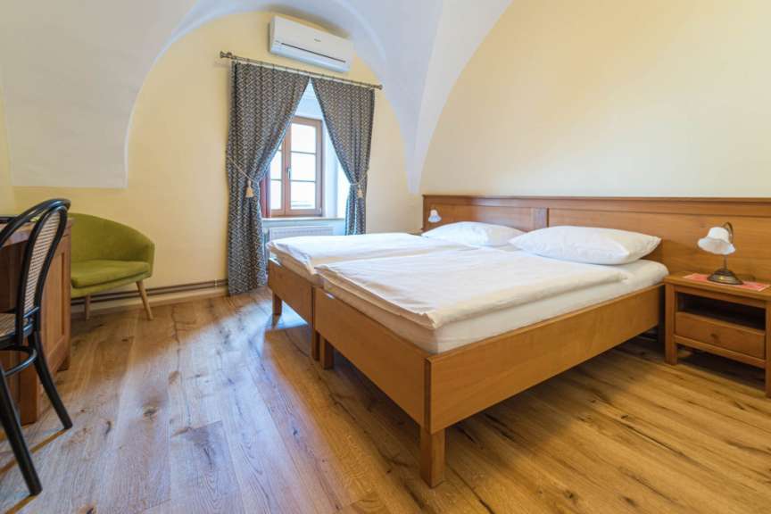 Ein Schlafzimmer mit zwei Betten und einem grünen Stuhl