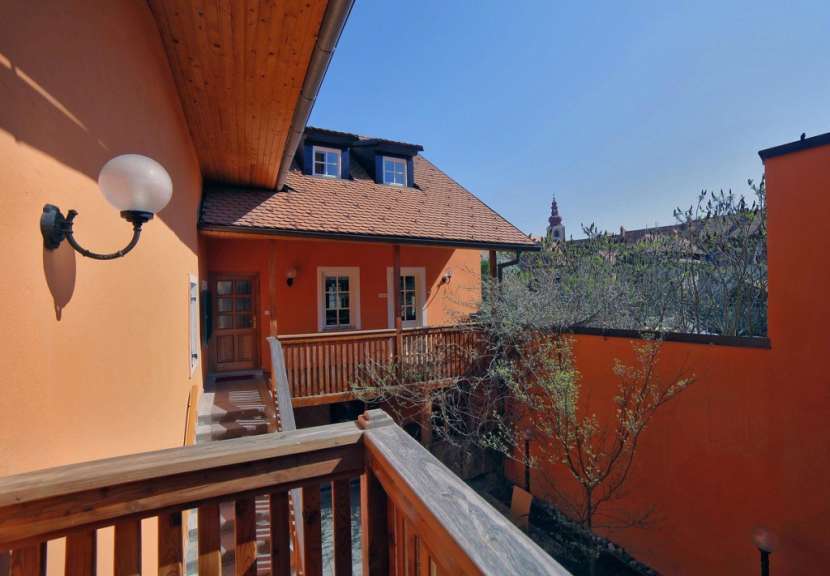 Ein orangefarbenes Gebäude mit einem Holzbalkon