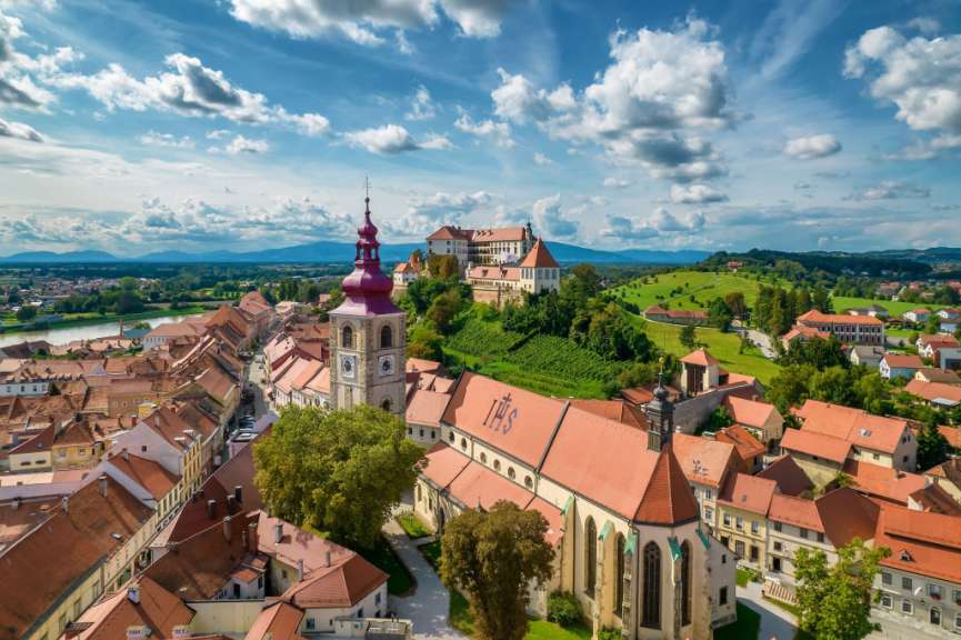 Eine Stadt mit einer Kirche und einem Schloss auf einem Hügel