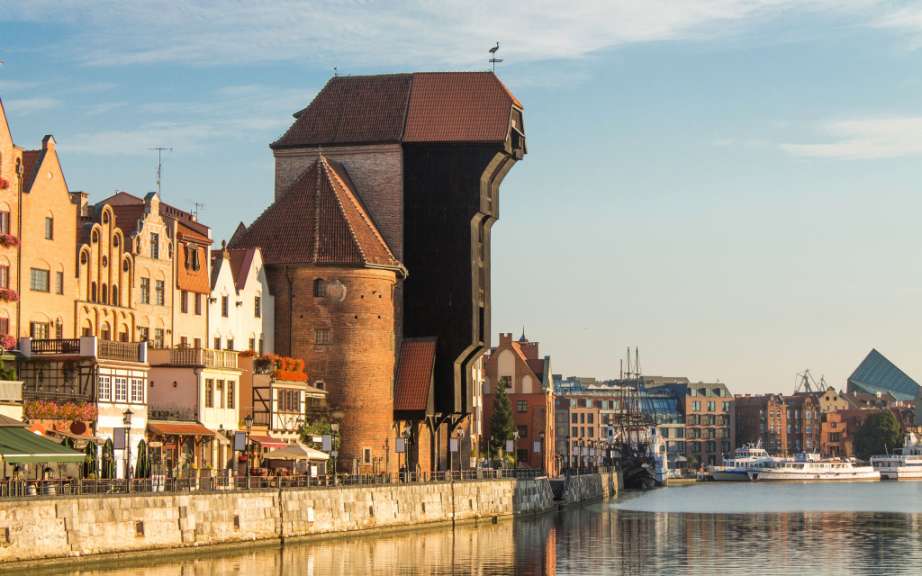 Eine Reihe von Gebäuden neben einem Fluss mit einem Turm darauf