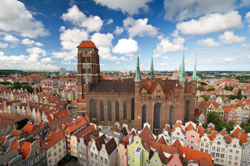 Eine große rote Kirche steht inmitten einer bunten Stadt