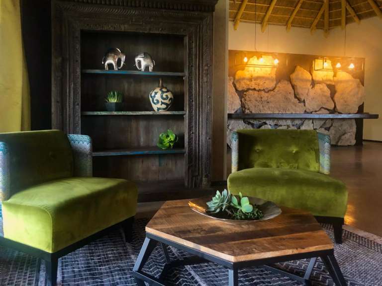 Ein Wohnzimmer mit grünen Stühlen und einem Holztisch