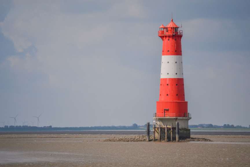 Ein rot-weißer Leuchtturm steht in der Mitte eines Sees
