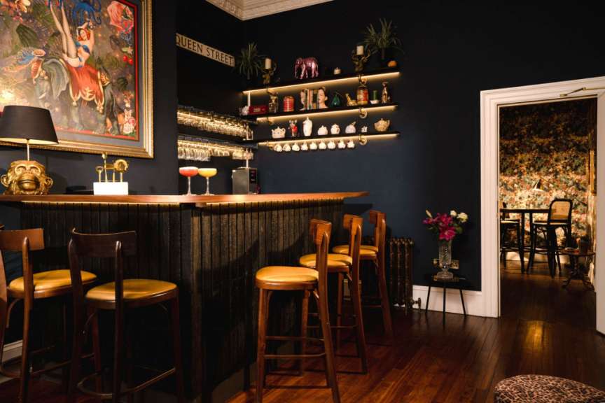 Eine Bar mit einem Schild an der Wand, das Queen Street sagt