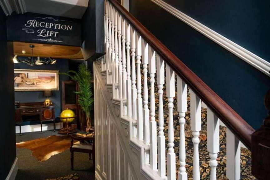 Eine Treppe in einem Haus mit einem Schild über der Treppe, das sagt „ reception lift “