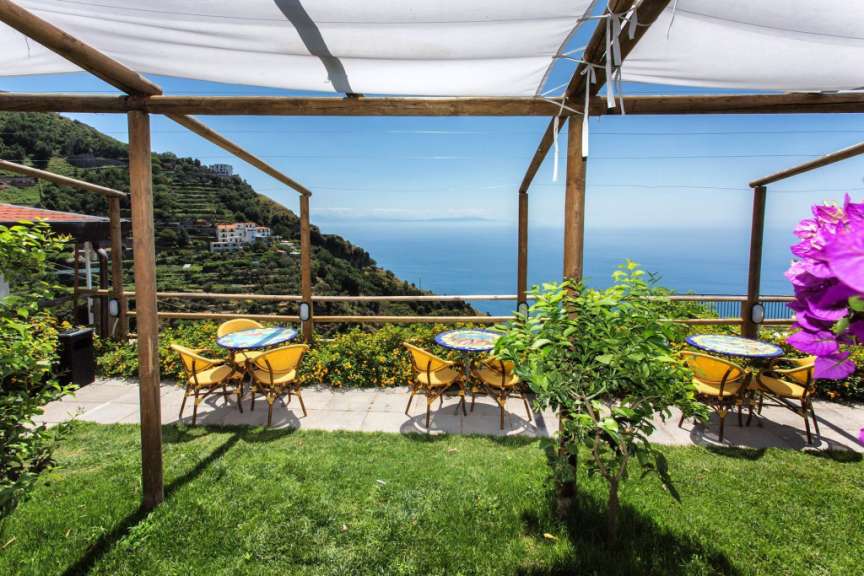 Tische und Stühle auf einer Terrasse mit Blick auf den Ozean