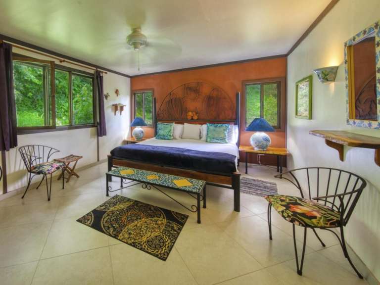 Ein Schlafzimmer mit einem Kingsize-Bett und zwei Stühlen