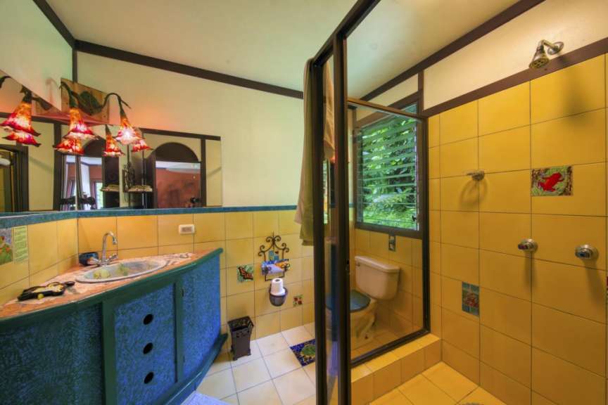 Ein Badezimmer mit gelben Fliesen und einer Dusche