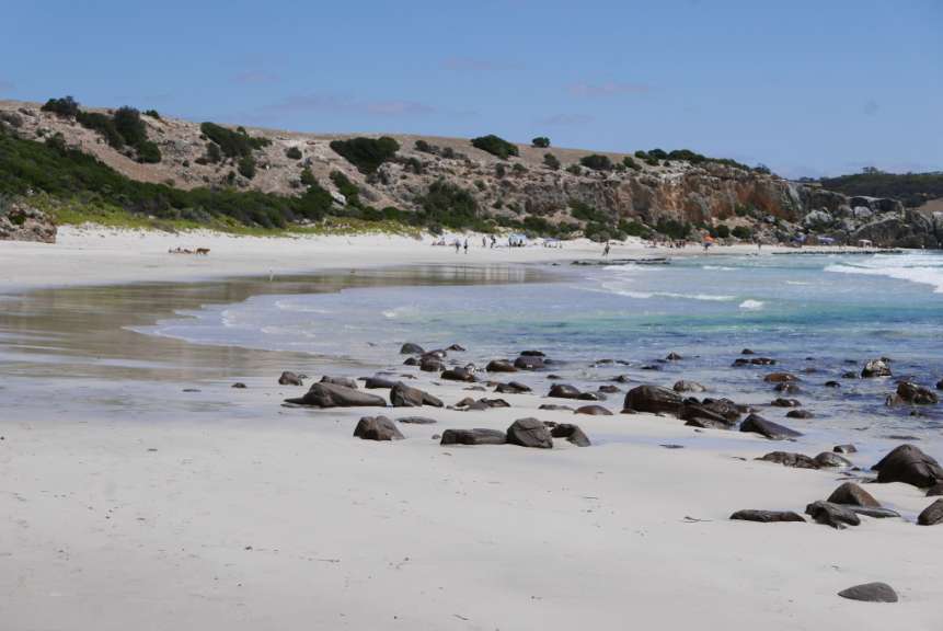 Eine Gruppe von Menschen geht an einem Strand entlang