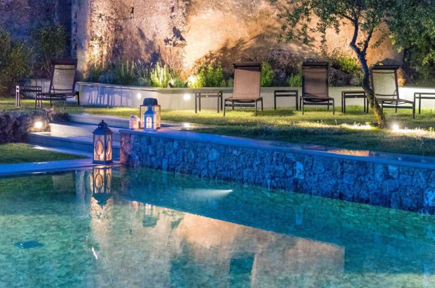 Ein Swimmingpool mit Liegestühlen und Laternen in der Nähe