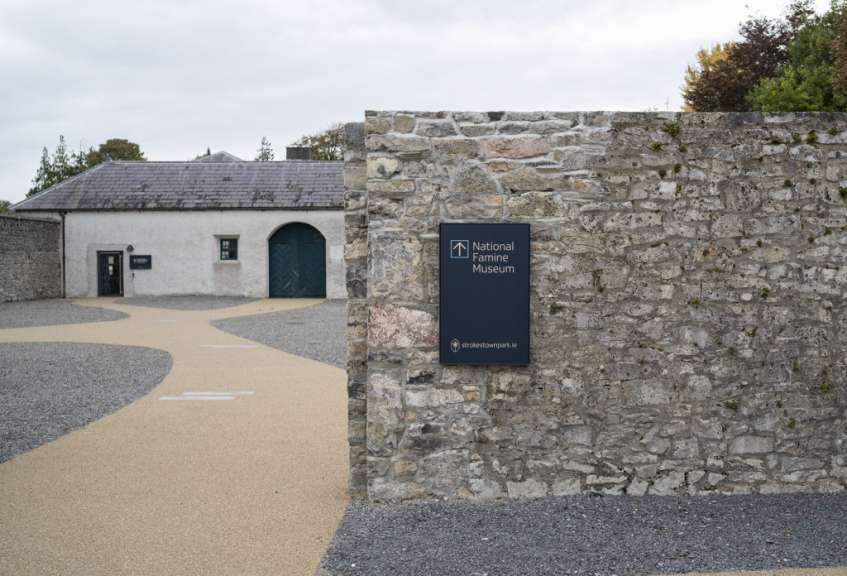 Ein Schild an einer Steinmauer zeigt den Weg zum nationalen Familienmuseum