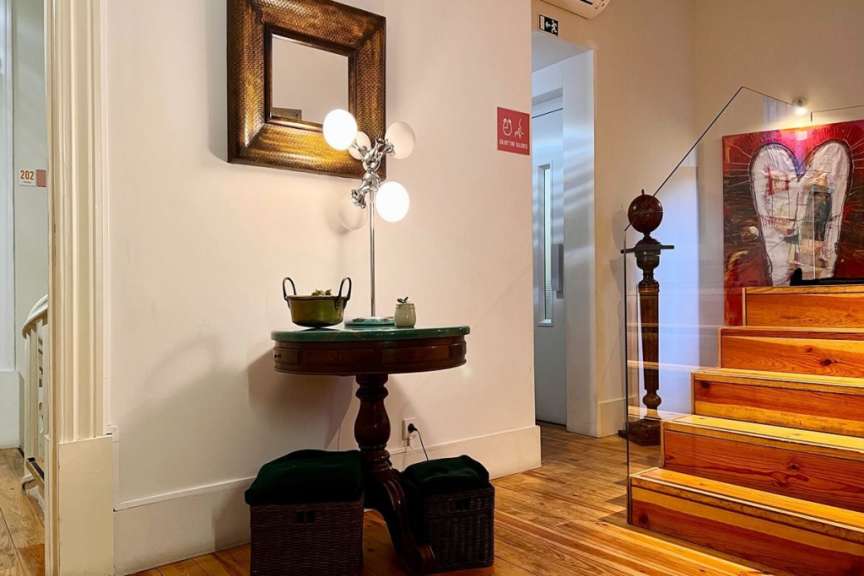 Ein kleiner Tisch mit einer Lampe darauf steht neben einer Treppe