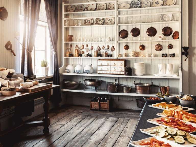 Eine Küche mit vielen Regalen und einem Tisch mit verschiedenen Speisen darauf