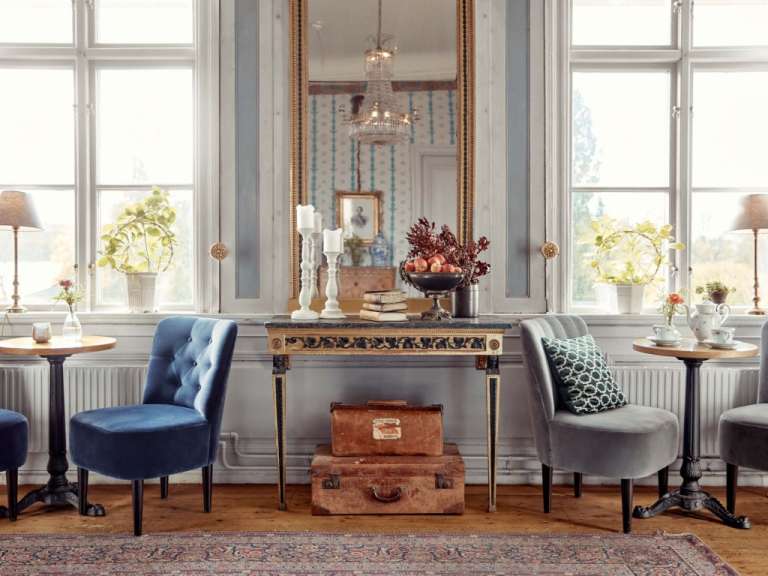 Ein Wohnzimmer mit zwei Stühlen und einem Tisch mit einem Koffer darauf