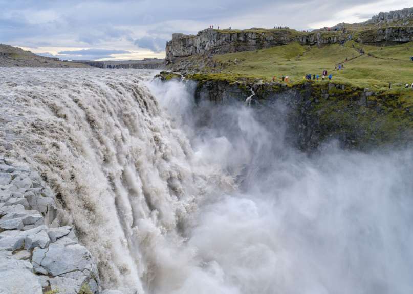 Eine Gruppe von Menschen steht an der Seite eines Wasserfalls