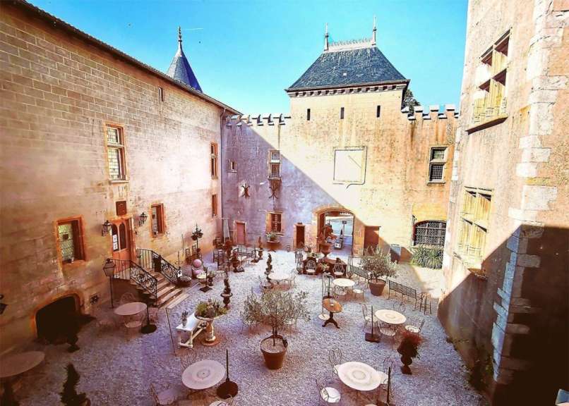 Ein kleiner Hof mit Tischen und Stühlen in einem Gebäude