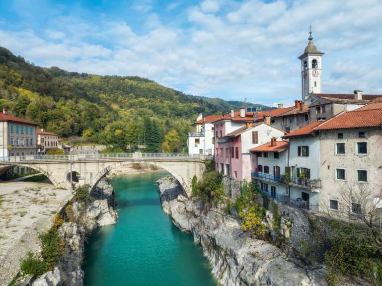 Eine Brücke über einen Fluss mit einer Kirche im Hintergrund