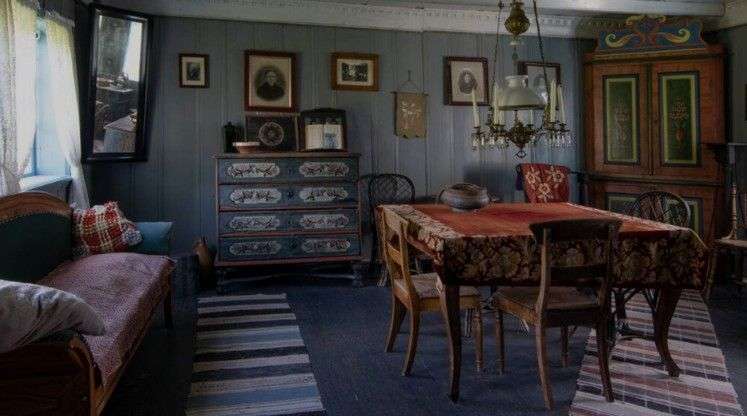 Ein Wohnzimmer mit einem Tisch und Stühlen und einer Kommode