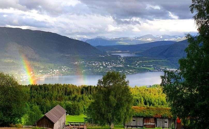 Ein Regenbogen scheint über einen See in den Bergen