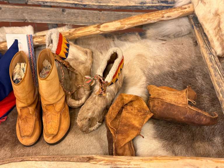 Ein paar braune stiefel sitzen auf einem pelzbedeckten boden
