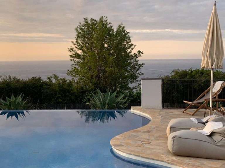 Ein Pool mit Liegestühlen und Sonnenschirmen umgeben