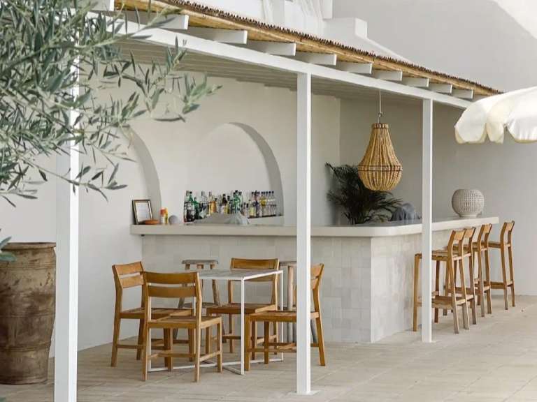 Eine Bar mit einem Tisch und Stühlen davor